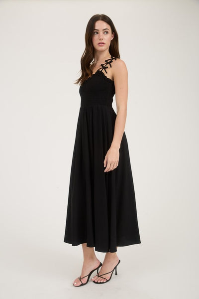 Woman wearing a black dress with thin straps on a white background