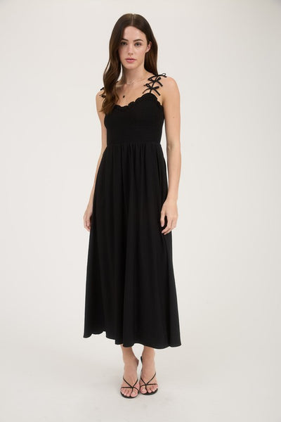 Black dress with lace-up back worn by a model on a white background