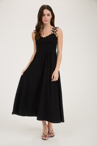 Woman wearing a black dress with lace straps on a white background