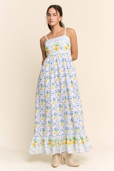 Woman wearing a floral dress with lemon pattern on a beige background