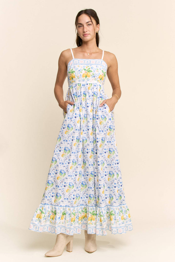 Woman wearing a floral dress with a lemon pattern on a beige background