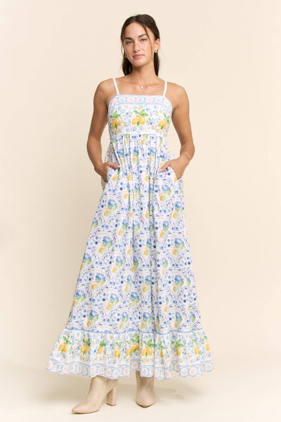 Woman wearing a floral dress with a lemon pattern on a beige background