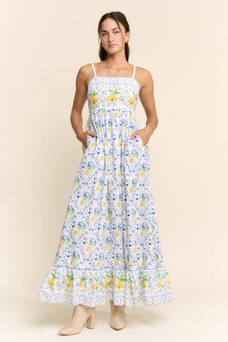 Woman wearing a floral dress with a lemon pattern on a beige background