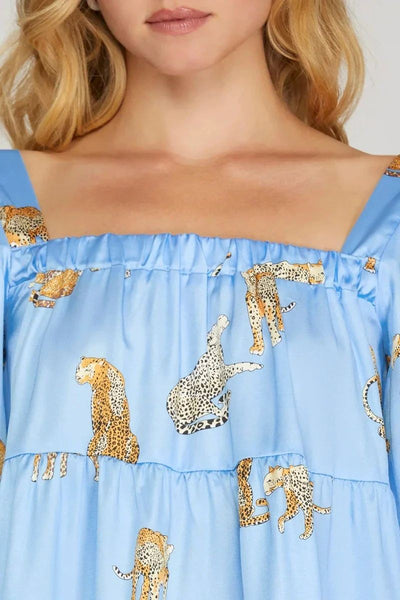 Blue top with animal print details on a plain background