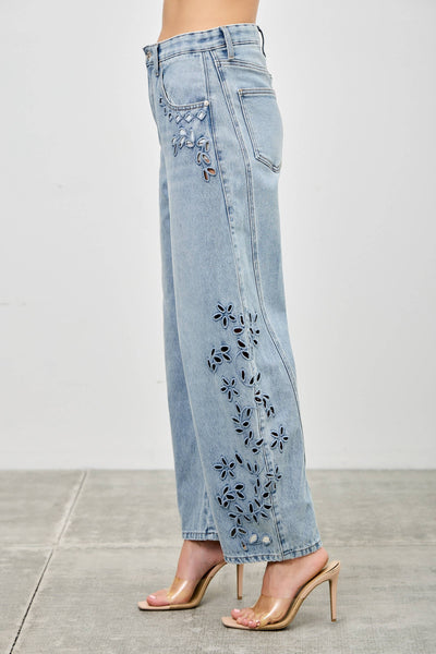 Light blue jeans with floral embroidery on a plain background