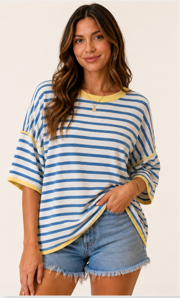 Woman wearing oversized blue striped top with yellow trim.