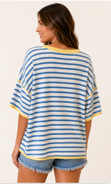 Back of woman wearing blue and white striped top with yellow trim.