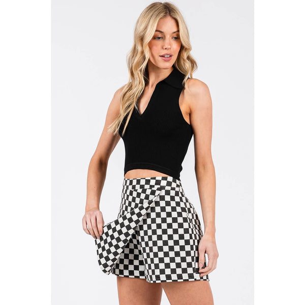 Woman wearing a black sleeveless top and checkered skirt on a white background