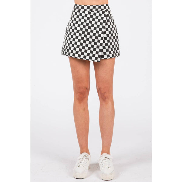 Person wearing a black and white checkered skirt on a white background