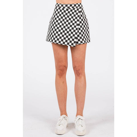 Person wearing a black and white checkered skirt on a white background