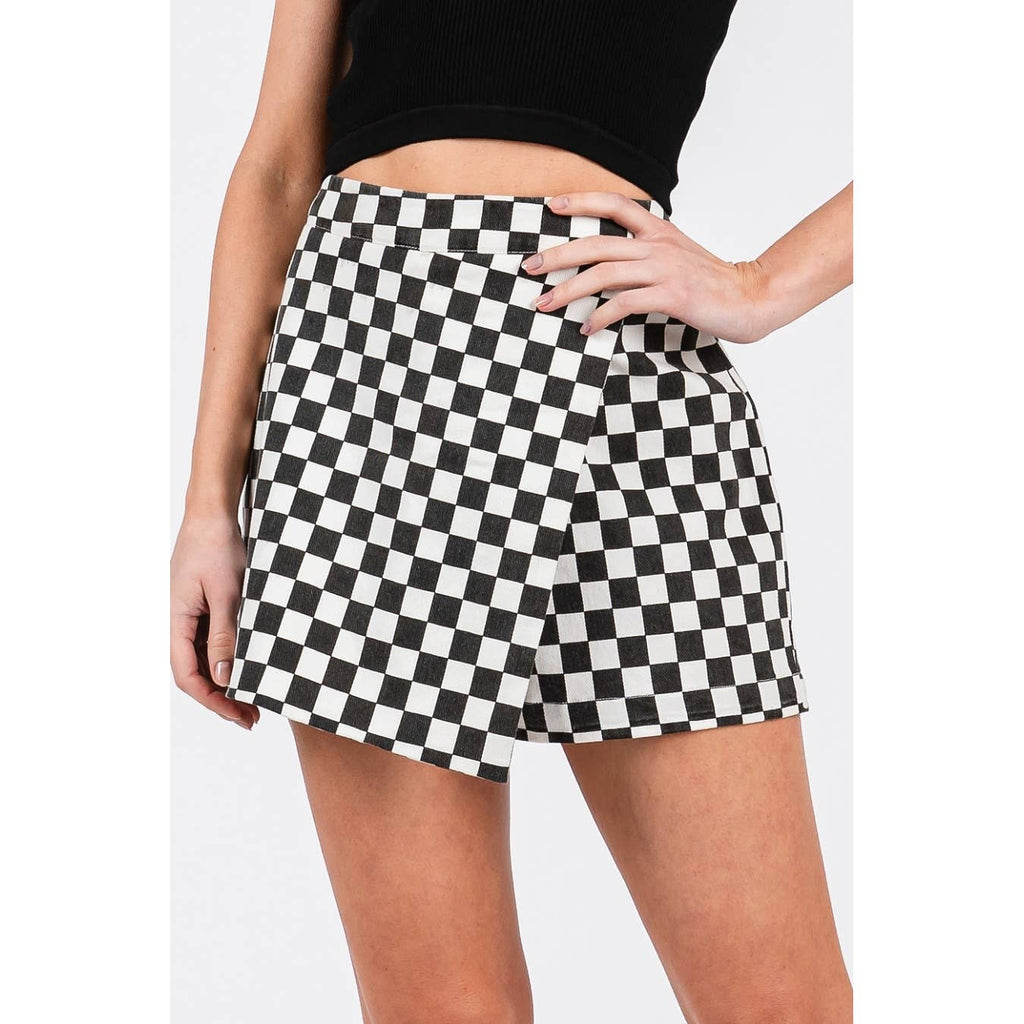 Person wearing a black and white checkered skirt on a plain background