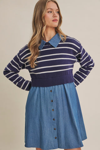A woman modeling a long-sleeve knit top with navy and white horizontal stripes and a blue denim collar, paired with a blue denim button-front skirt, against a plain beige studio background.