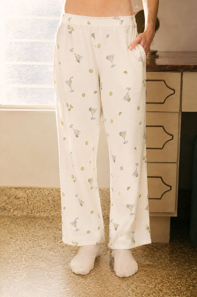 Person wearing white pajama pants with a pattern in a room.