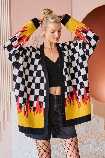 Woman wearing a checkered cardigan with flame designs in a stylish setting