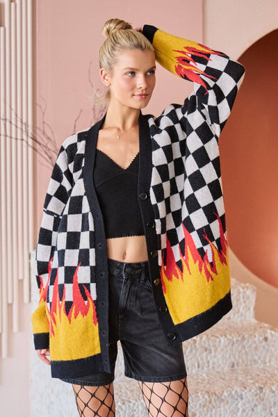 Woman wearing a checkered cardigan with flame patterns in a stylish setting.