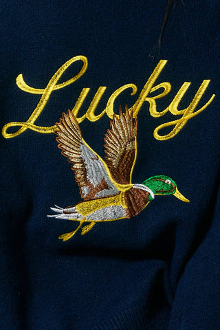 Embroidered duck and 'Lucky' text on a dark fabric background
