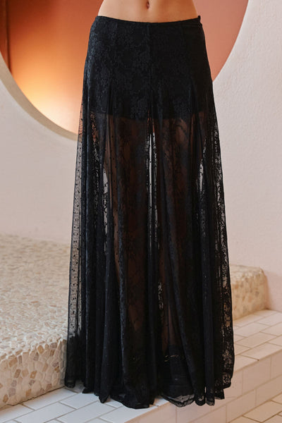 Black lace skirt worn by a person, standing against a neutral background.