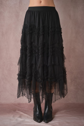Black tiered skirt worn by a person on a plain background