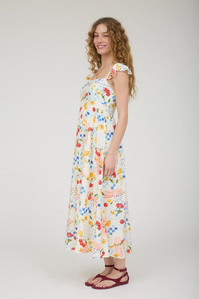 Woman wearing a colorful floral fruit dress on a white background