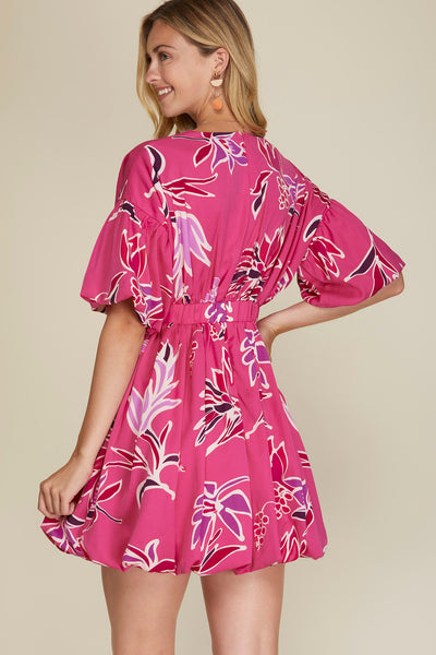 Woman wearing a pink floral dress against a beige background