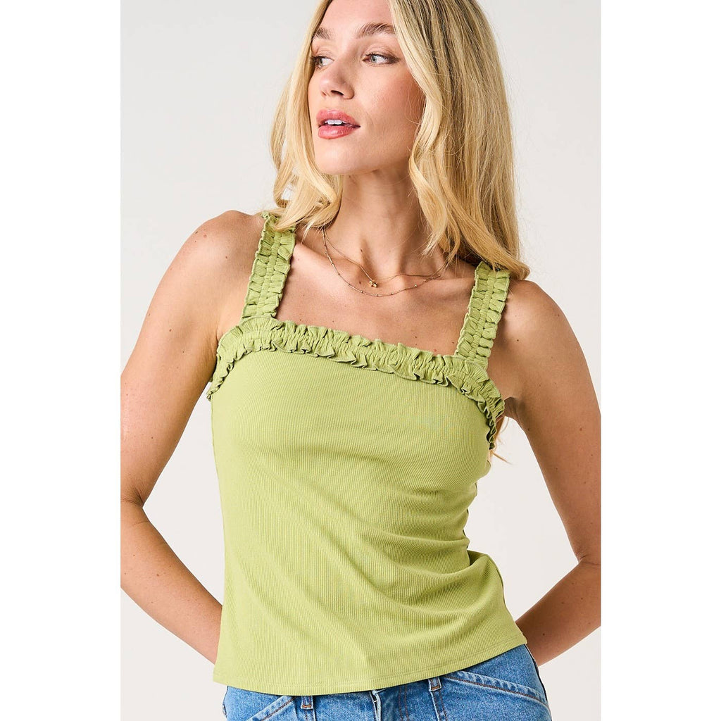 Woman wearing a green tank top with ruffled straps on a white background