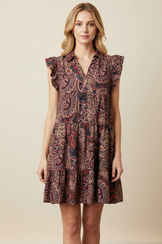 Woman wearing paisley flowy shirt dress. 