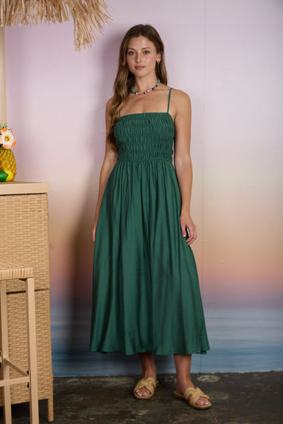 Woman wearing a green dress standing against a blurred background