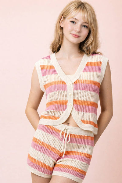 Woman wearing a colorful striped outfit with a pink background