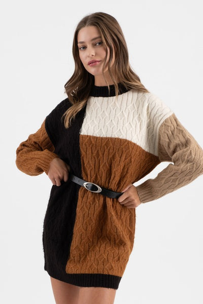 Woman wearing a color-blocked sweater dress with a belt on a white background