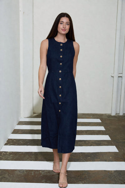 Woman wearing a navy sleeveless dress with buttons on a white and gray striped floor.