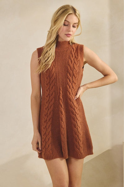 Woman wearing a brown knitted dress against a beige background