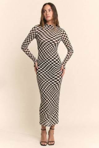 Woman wearing a black and white checkered dress on a beige background