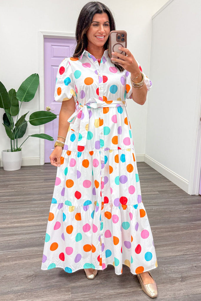 Woman wearing multi-color polka dot maxi dress.