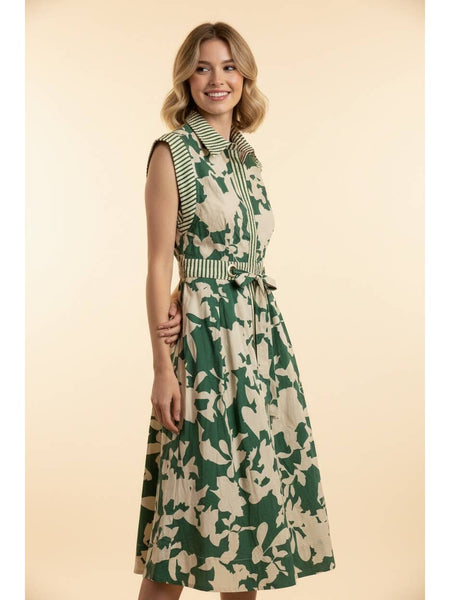 A woman modeling a sleeveless midi dress with a green and beige abstract floral pattern, a striped collar, and a matching tie belt, set against a solid beige background.