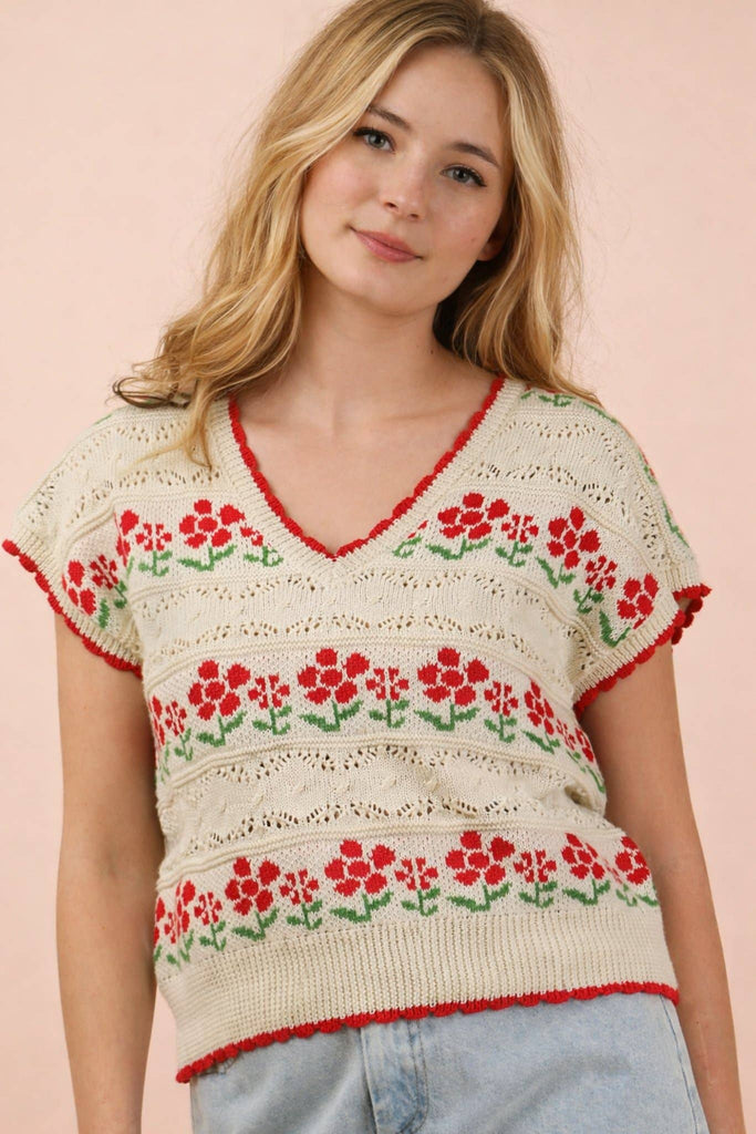 Woman wearing a floral-patterned sweater against a pink background