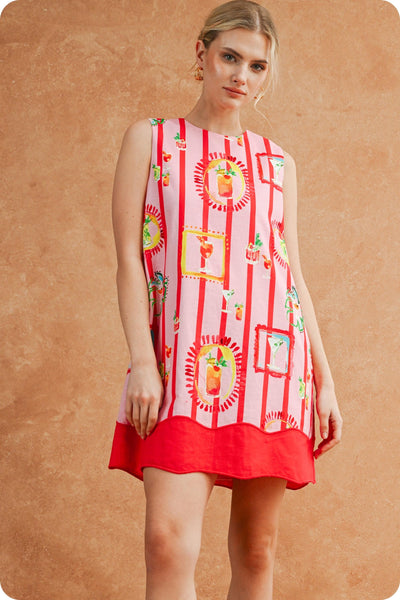 Woman wearing a red dress with colorful patterns on a beige background