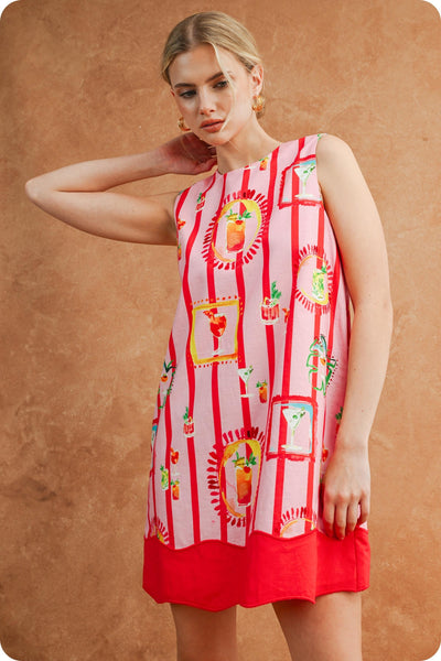 Woman wearing a red and white patterned dress against a brown background