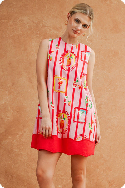 Woman wearing a red and white patterned dress against a beige background