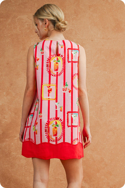 Woman wearing a red and white patterned dress against a beige background
