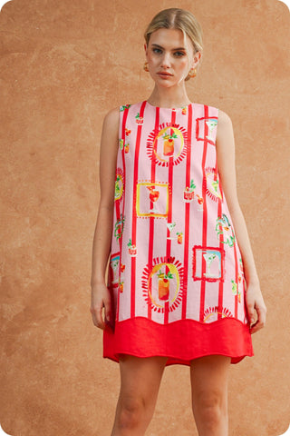 Woman wearing a red and white patterned dress against a brown background