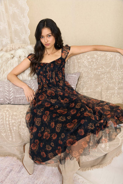 Women’s black floral organza midi dress with rust rose print, sweetheart neckline, sheer short sleeves and shirred waist.
