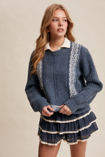 Woman wearing a blue sweater with white trim and a matching skirt on a beige background