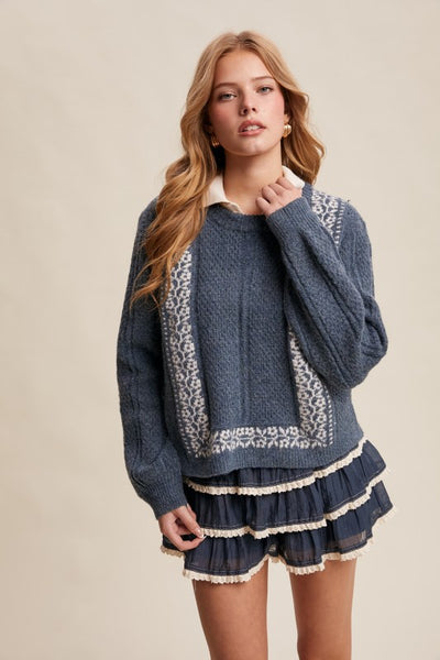 Woman wearing a blue sweater with lace details on a beige background
