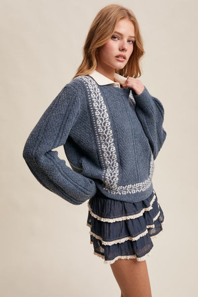 Woman wearing a blue sweater with lace details on a beige background
