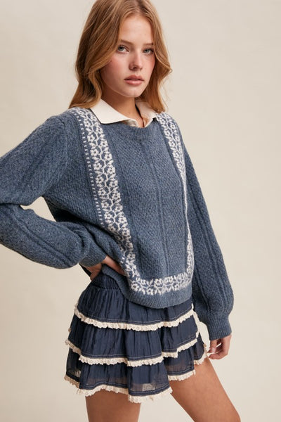 Woman wearing a blue sweater with lace details and a matching skirt on a beige background