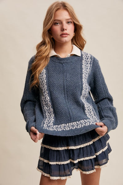 Woman wearing a blue sweater with lace details on a beige background