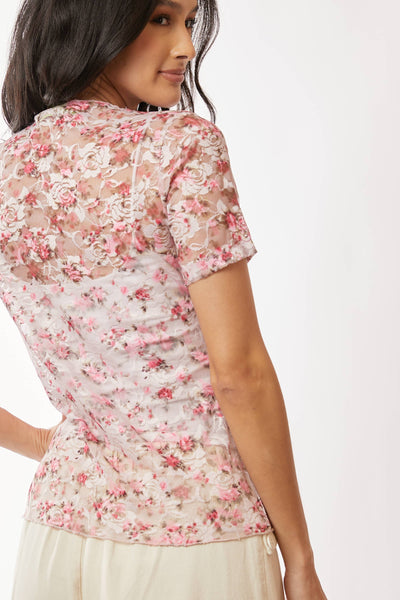 Woman wearing a floral blouse with a plain background