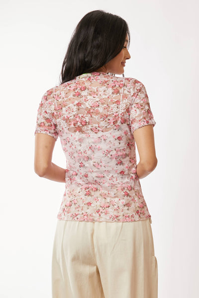 Woman wearing a floral top and beige pants on a white background
