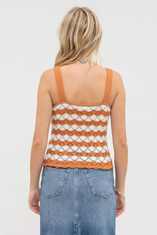 Woman wearing a striped tank top and jeans on a plain background