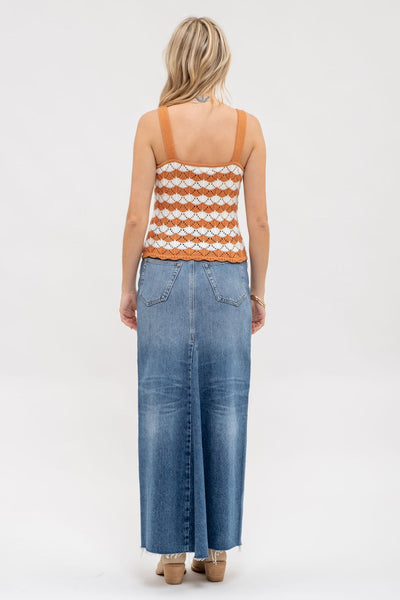 Woman wearing a striped tank top and denim overalls on a white background